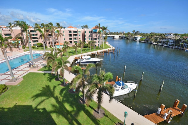 dock area with a community pool, a water view, a patio area, and a yard