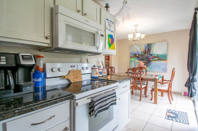 kitchen featuring a chandelier, hanging light fixtures, electric range oven, dark stone countertops, and light tile patterned flooring