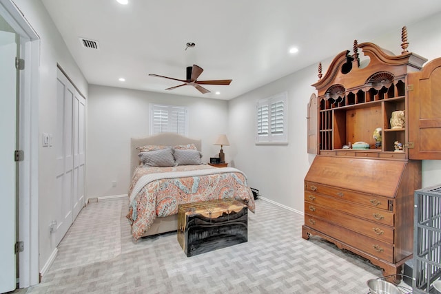 bedroom with a closet, ceiling fan, and light colored carpet