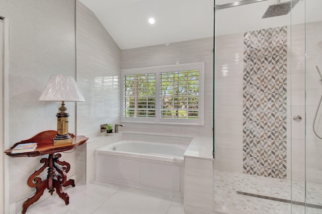 bathroom featuring independent shower and bath, tile patterned floors, and lofted ceiling