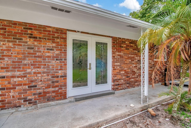 view of exterior entry with french doors and a patio area