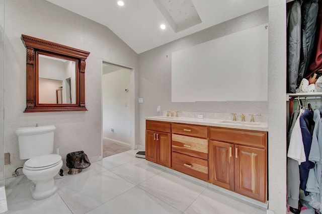 bathroom with toilet, lofted ceiling, vanity, and tile patterned floors