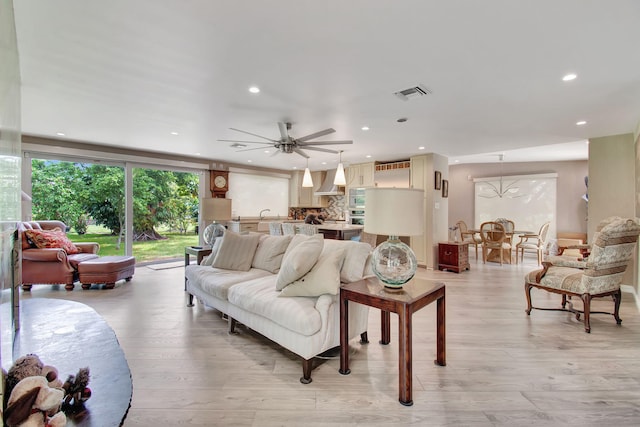 living room with light hardwood / wood-style floors and ceiling fan