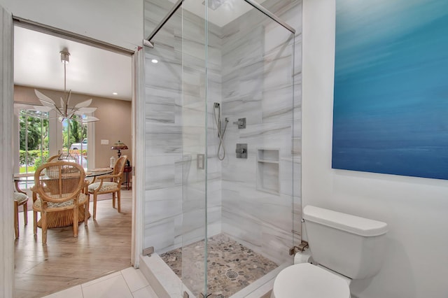 bathroom featuring tile patterned flooring, toilet, a chandelier, and walk in shower