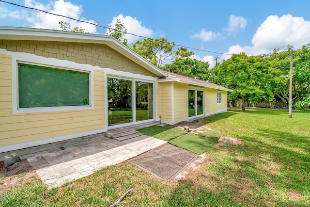 back of property with a patio and a yard