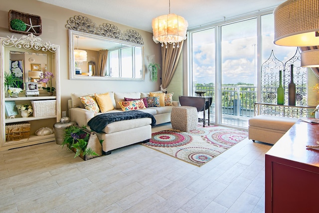 living room with light wood-type flooring, a notable chandelier, and a wall of windows