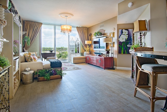 living area with a textured ceiling, floor to ceiling windows, a chandelier, and hardwood / wood-style flooring