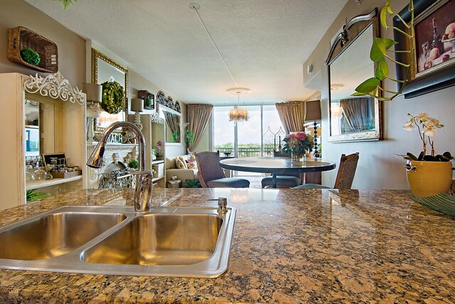 kitchen featuring sink, a textured ceiling, and an inviting chandelier