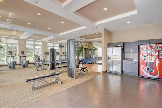 gym with recessed lighting, visible vents, and a tray ceiling