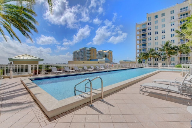 pool with a patio and fence