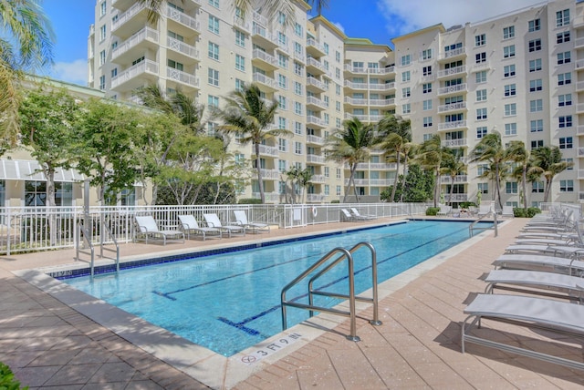 pool with a patio area and fence