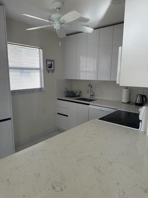 kitchen with ceiling fan, sink, light stone countertops, and white cabinetry