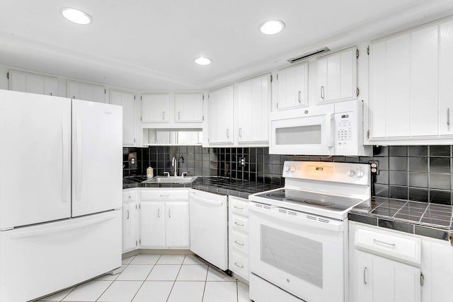 kitchen with white cabinetry, light tile patterned floors, tile countertops, and white appliances