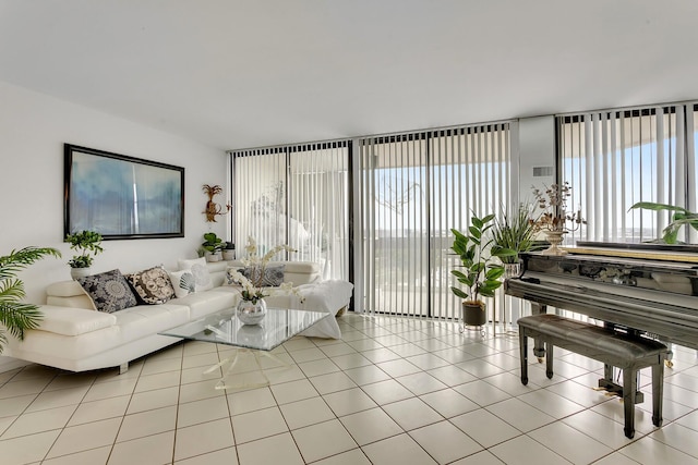 living room with a wall of windows and light tile patterned flooring