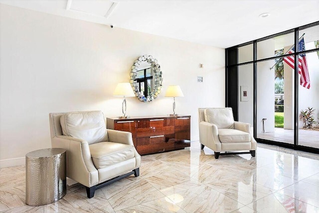 living area with a wall of windows, marble finish floor, and baseboards