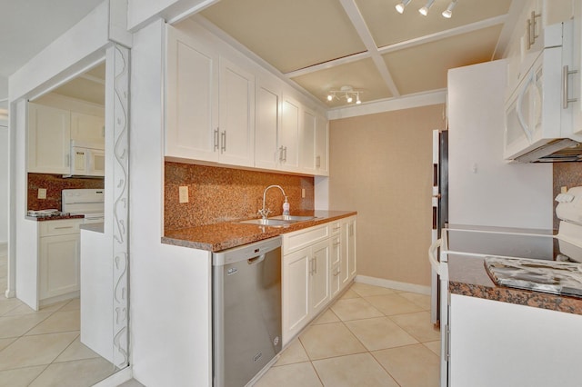 kitchen with white appliances, white cabinetry, tasteful backsplash, a sink, and light tile patterned floors