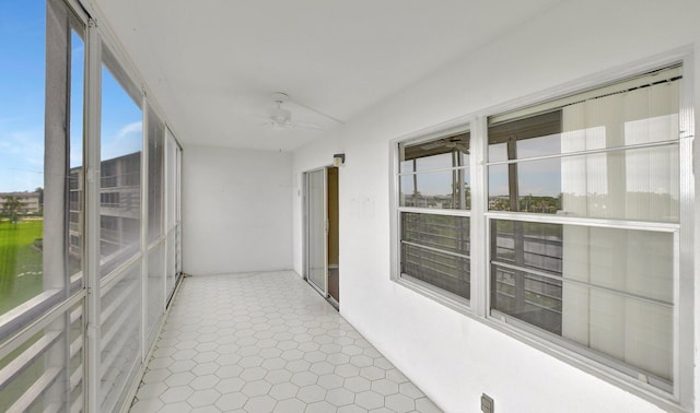 unfurnished sunroom featuring ceiling fan