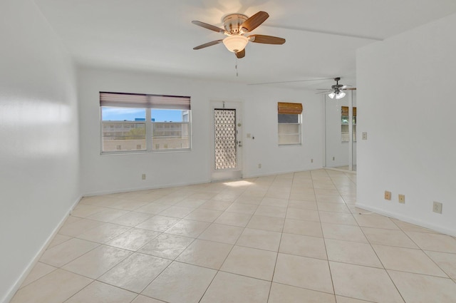 tiled spare room featuring ceiling fan