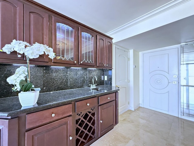 kitchen featuring ornamental molding, sink, backsplash, and dark stone counters