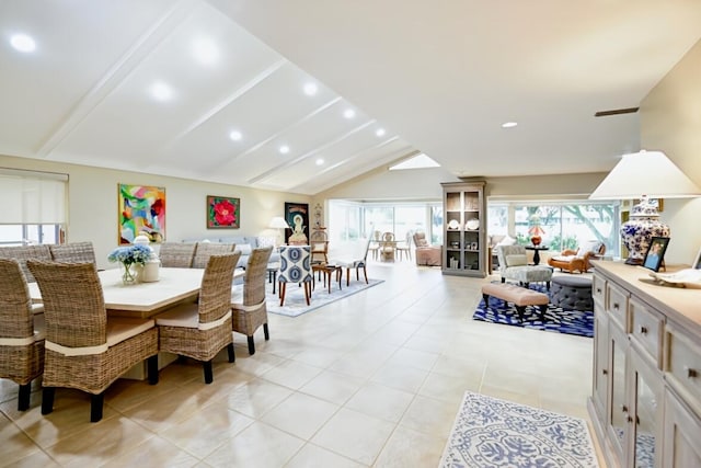 dining area featuring light tile patterned floors and vaulted ceiling