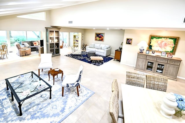 living room featuring visible vents, baseboards, and vaulted ceiling