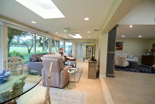 tiled living room featuring ceiling fan and a skylight