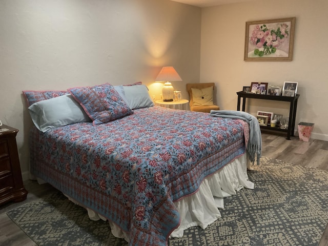 bedroom with baseboards and wood finished floors