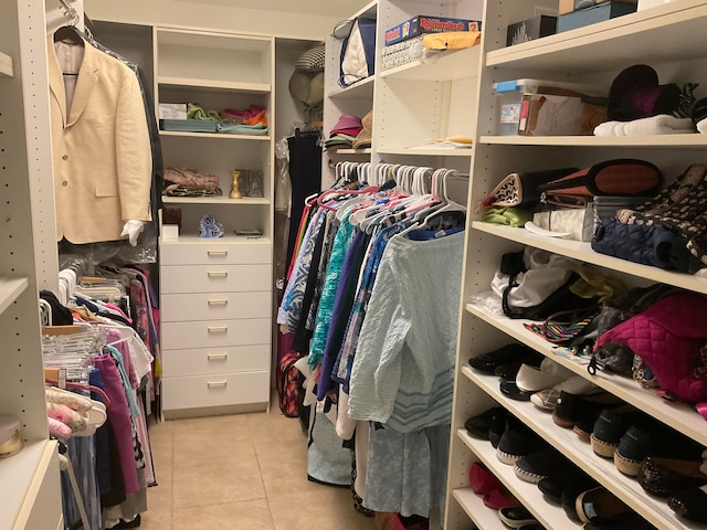 walk in closet with light tile patterned floors