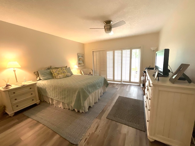 bedroom featuring hardwood / wood-style floors, a textured ceiling, and ceiling fan