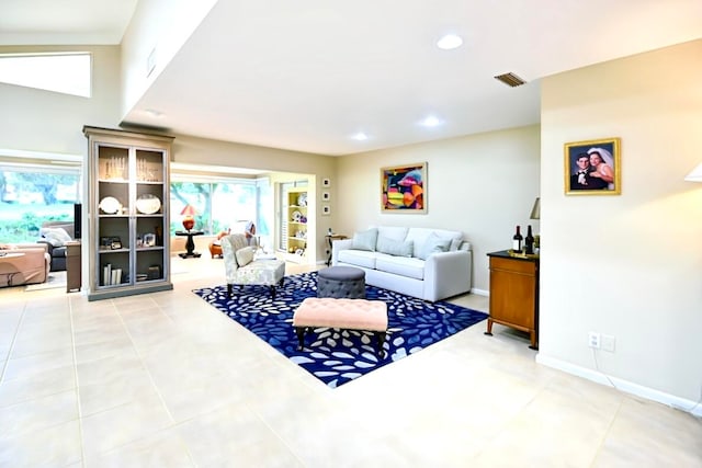 living room featuring vaulted ceiling and tile patterned flooring