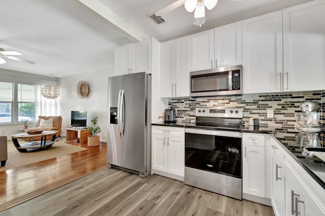 kitchen with appliances with stainless steel finishes, light hardwood / wood-style flooring, decorative backsplash, ceiling fan, and white cabinets