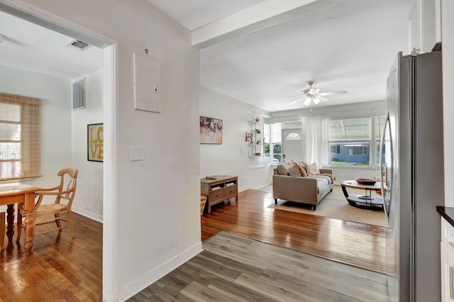 living room with baseboards, visible vents, ceiling fan, and wood finished floors