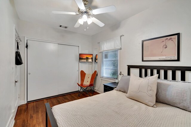 bedroom with ceiling fan, a closet, and dark wood-type flooring