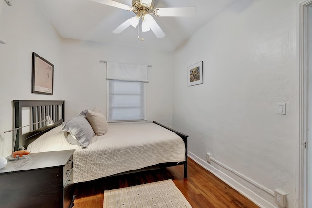 bedroom with ceiling fan, baseboards, and wood finished floors