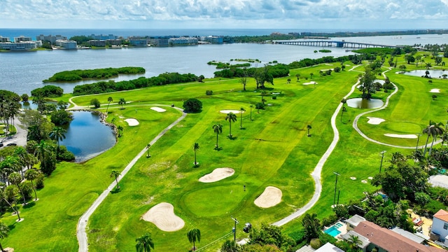 drone / aerial view featuring golf course view and a water view