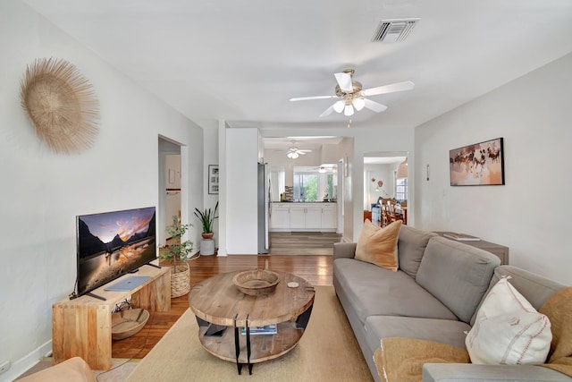 living room featuring ceiling fan and light hardwood / wood-style floors