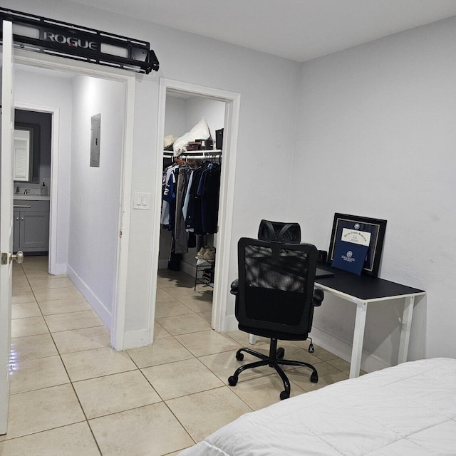 bedroom with light tile patterned floors, connected bathroom, a closet, and a walk in closet