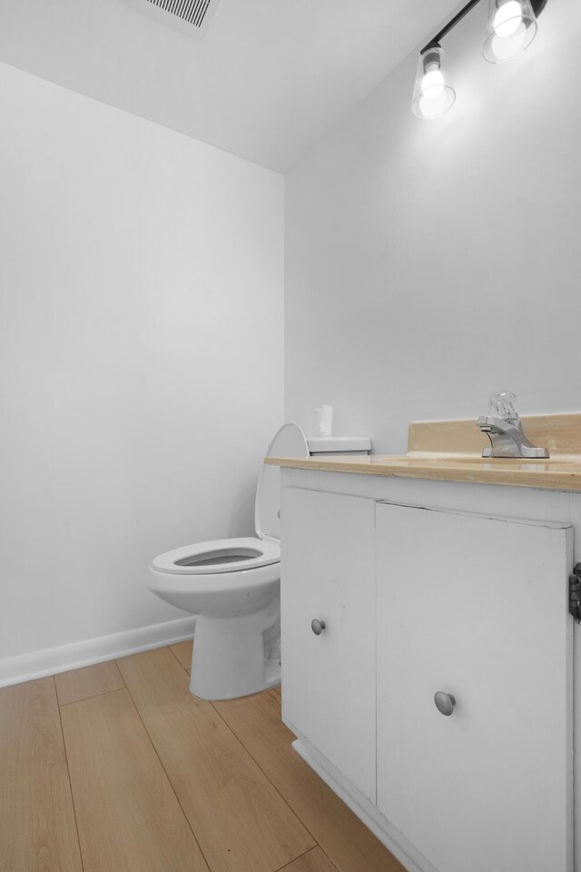 bathroom with vanity, toilet, and wood-type flooring