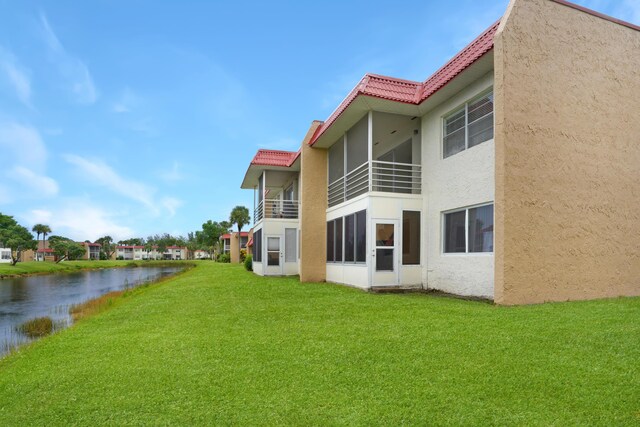 exterior space with a water view and a lawn