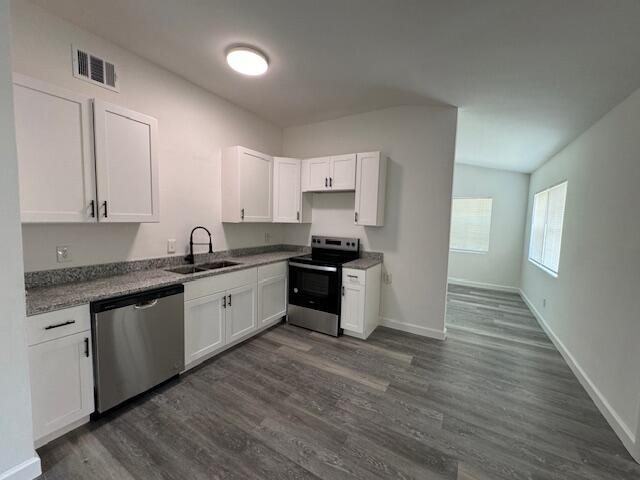 kitchen featuring appliances with stainless steel finishes, dark hardwood / wood-style flooring, and sink