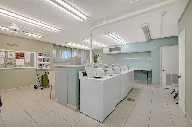 laundry area featuring ceiling fan, independent washer and dryer, a textured ceiling, and light tile patterned floors