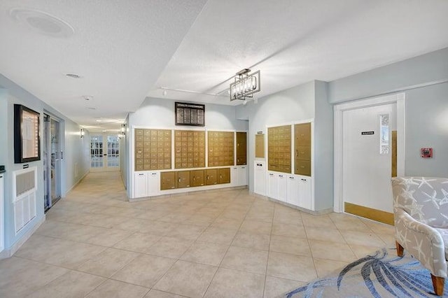 interior space featuring light tile patterned flooring, a textured ceiling, and a notable chandelier