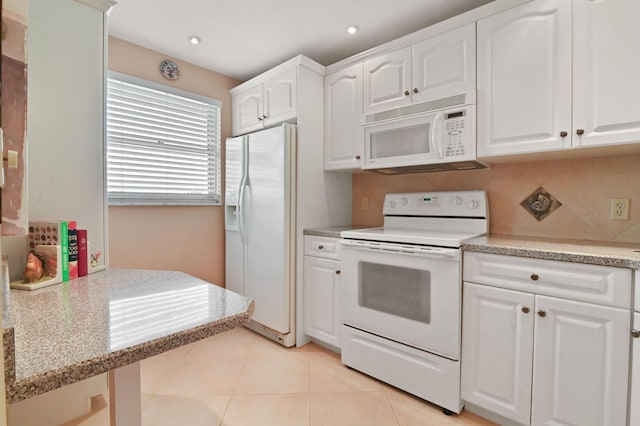 kitchen featuring backsplash, white cabinets, light tile patterned floors, light stone counters, and white appliances