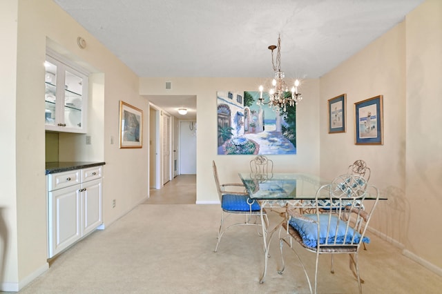 carpeted dining space featuring an inviting chandelier and a textured ceiling