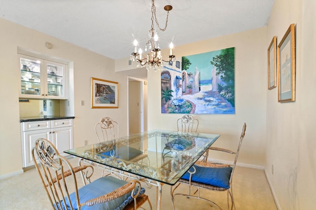 dining area with an inviting chandelier and light carpet