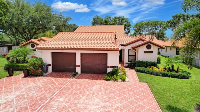 mediterranean / spanish-style home with a front yard and a garage