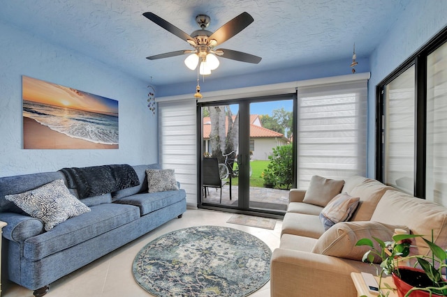 living room featuring ceiling fan and a textured ceiling