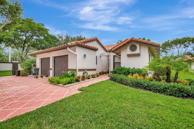 mediterranean / spanish house with a front yard and a garage