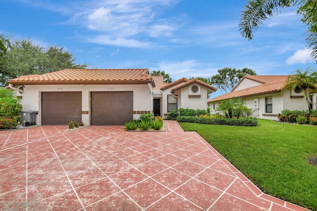 mediterranean / spanish home featuring a front yard and a garage