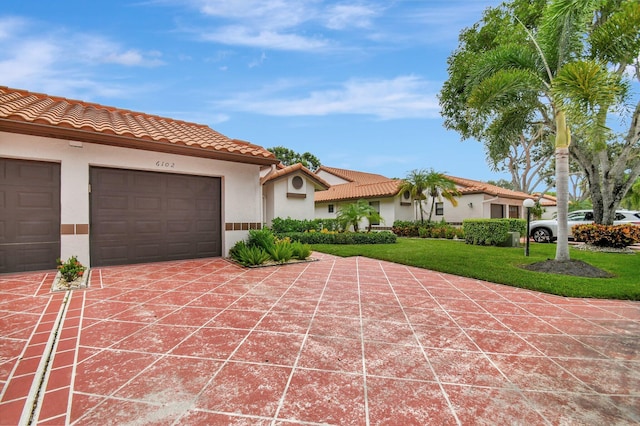 mediterranean / spanish home featuring a front lawn and a garage